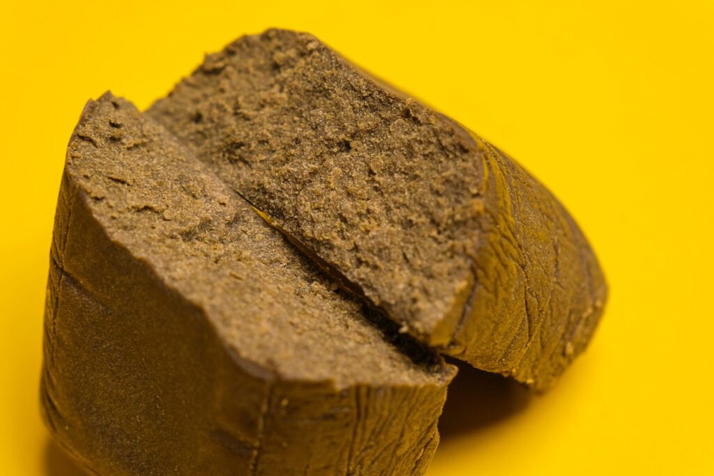 Close-up of cannabis hash block on yellow background