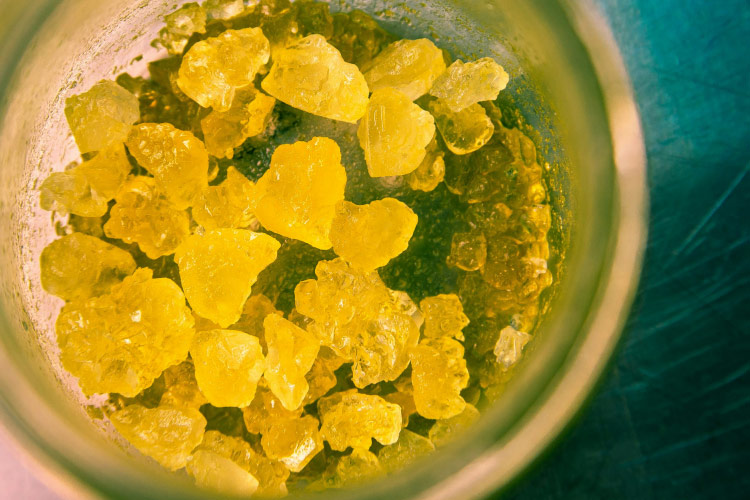 Yellow cannabis concentrate crystals in glass container