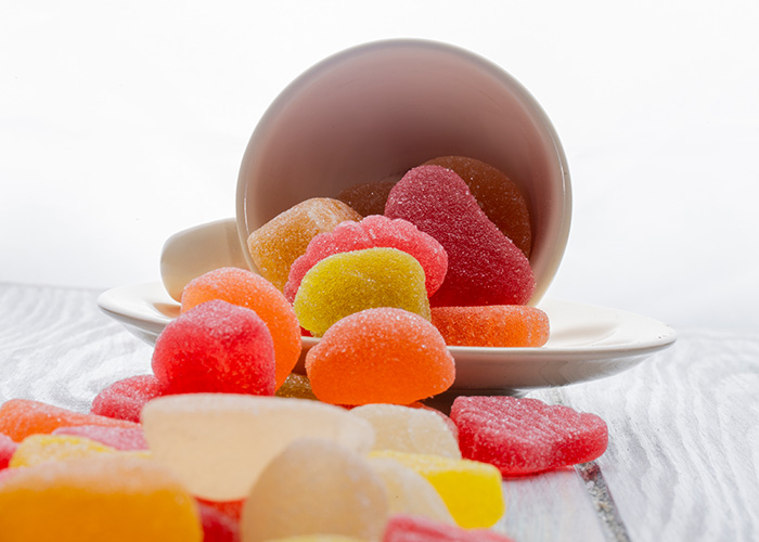 Bowl of assorted gummies on a white table