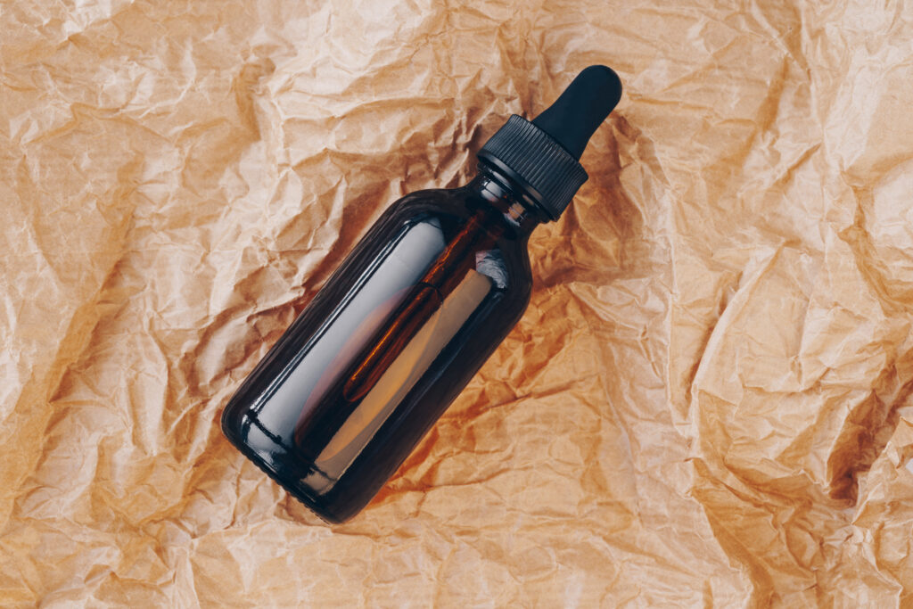 Amber tincture bottle on crumpled paper background