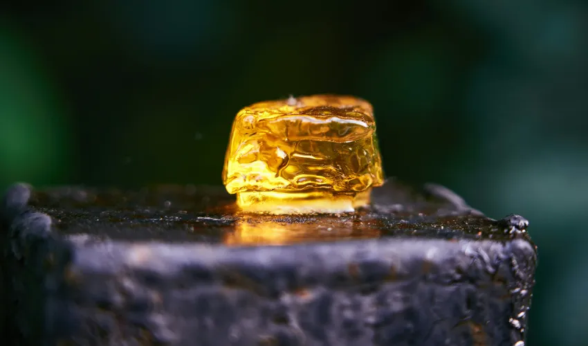 Yellow THC diamond concentrate crystal on a wooden block